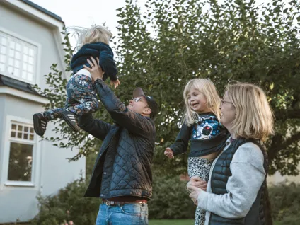 En grupp människor som står framför ett hus.