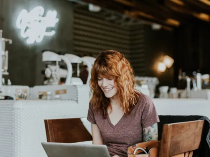 A woman sitting at a table with a laptop.