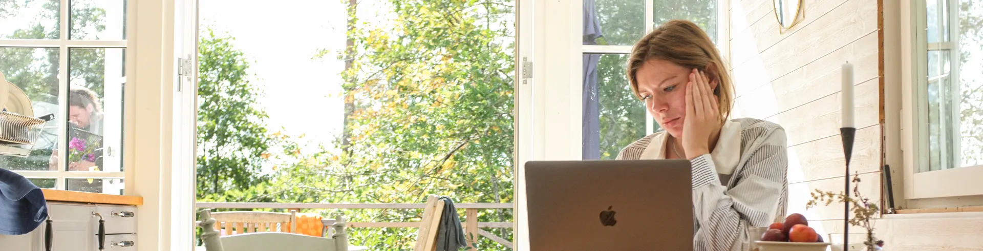 A woman sitting at a table using a laptop computer.