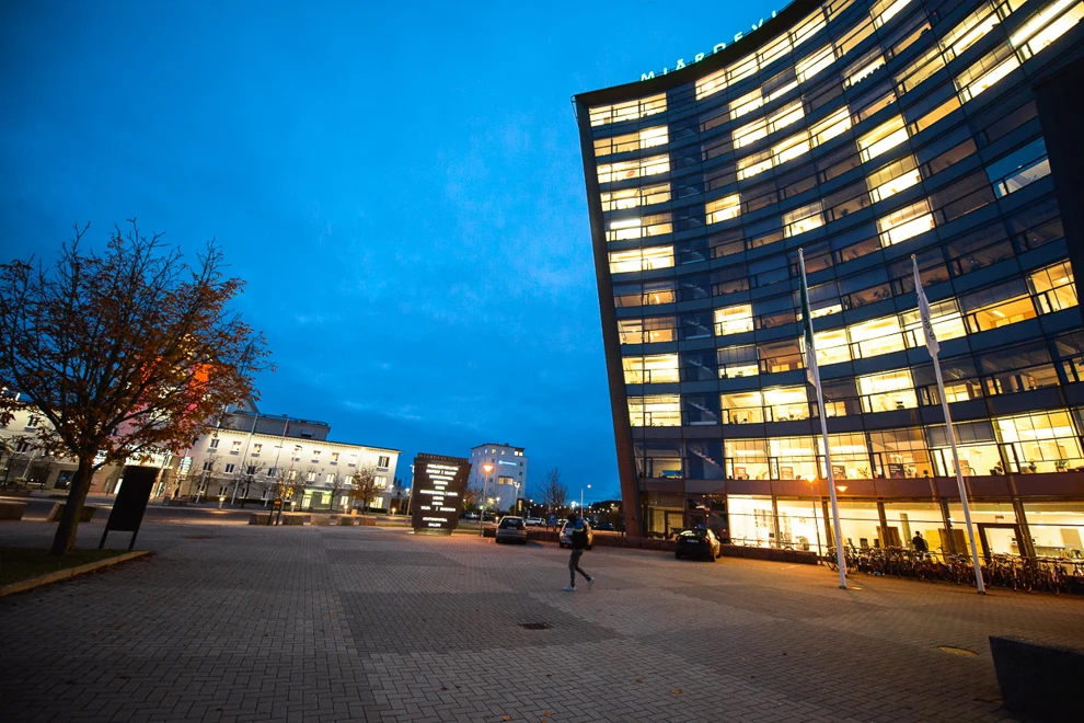 A person walking in front of a building at night.